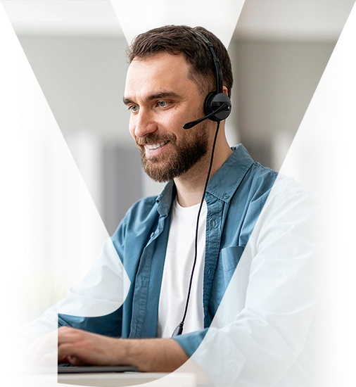 Man wearing a headset and working at a computer.