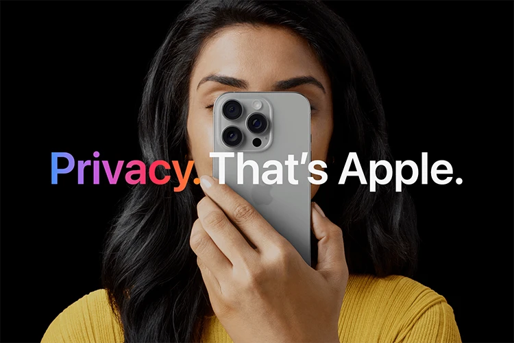 Woman holding an iPhone in front of her face against a black background, with the words 'Privacy. That's Apple.'