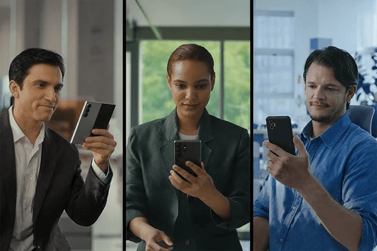 Three business professionals using Samsung smartphones in a workplace