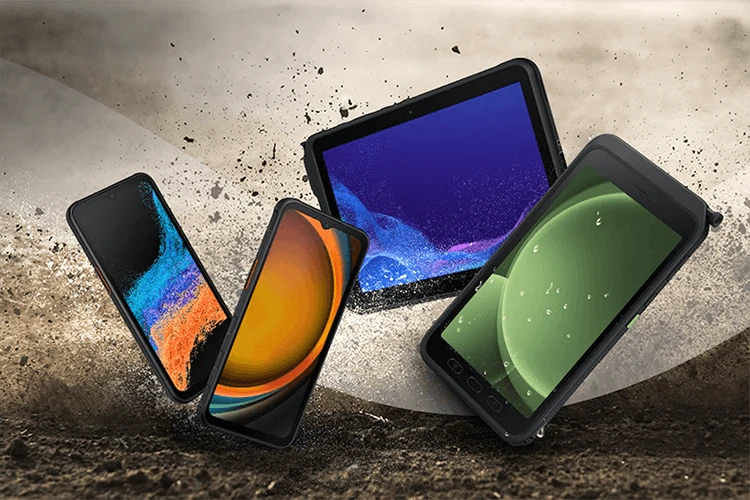 Samsung rugged smartphones and tablet shown outdoors on a dusty, rugged surface
