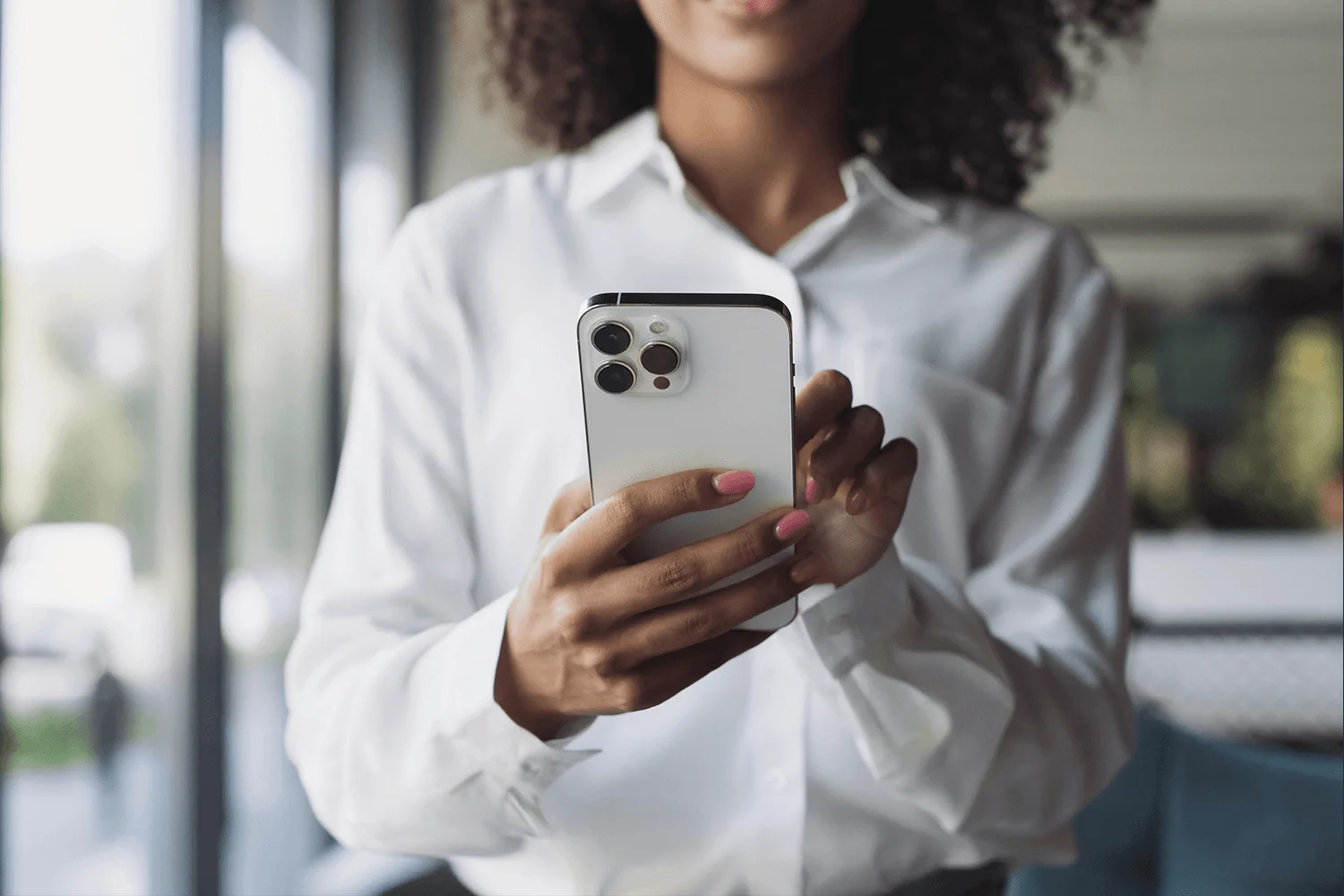 Close-up of a working professional in an office space using a mobile phone