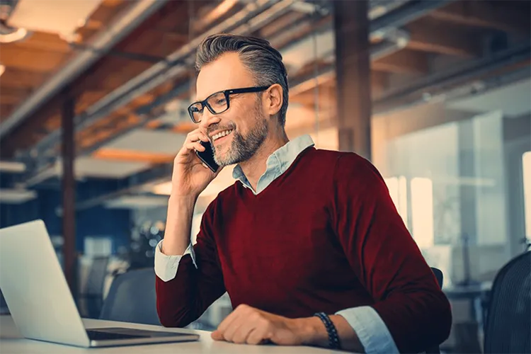Business professional making a mobile call at his desk