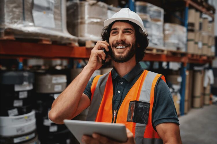 Call Us - Male worker smiling on mobile phone