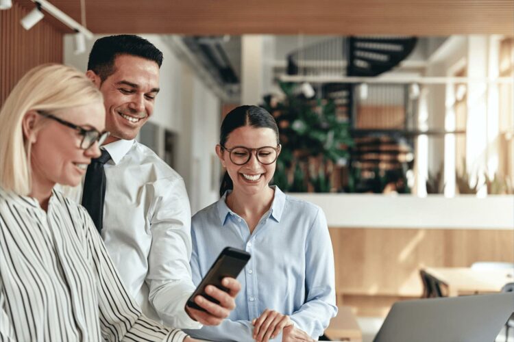 Office colleagues smiling at work mobile phone